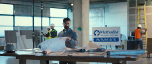 Men working by sign reading Methodist Health System Future Site
