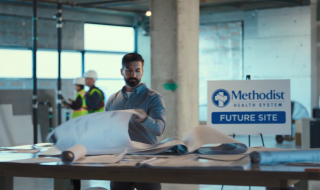 Men working by sign reading Methodist Health System Future Site
