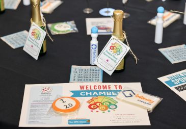 Table at Chamber Bingo Night with bingo cards and champagne bottles