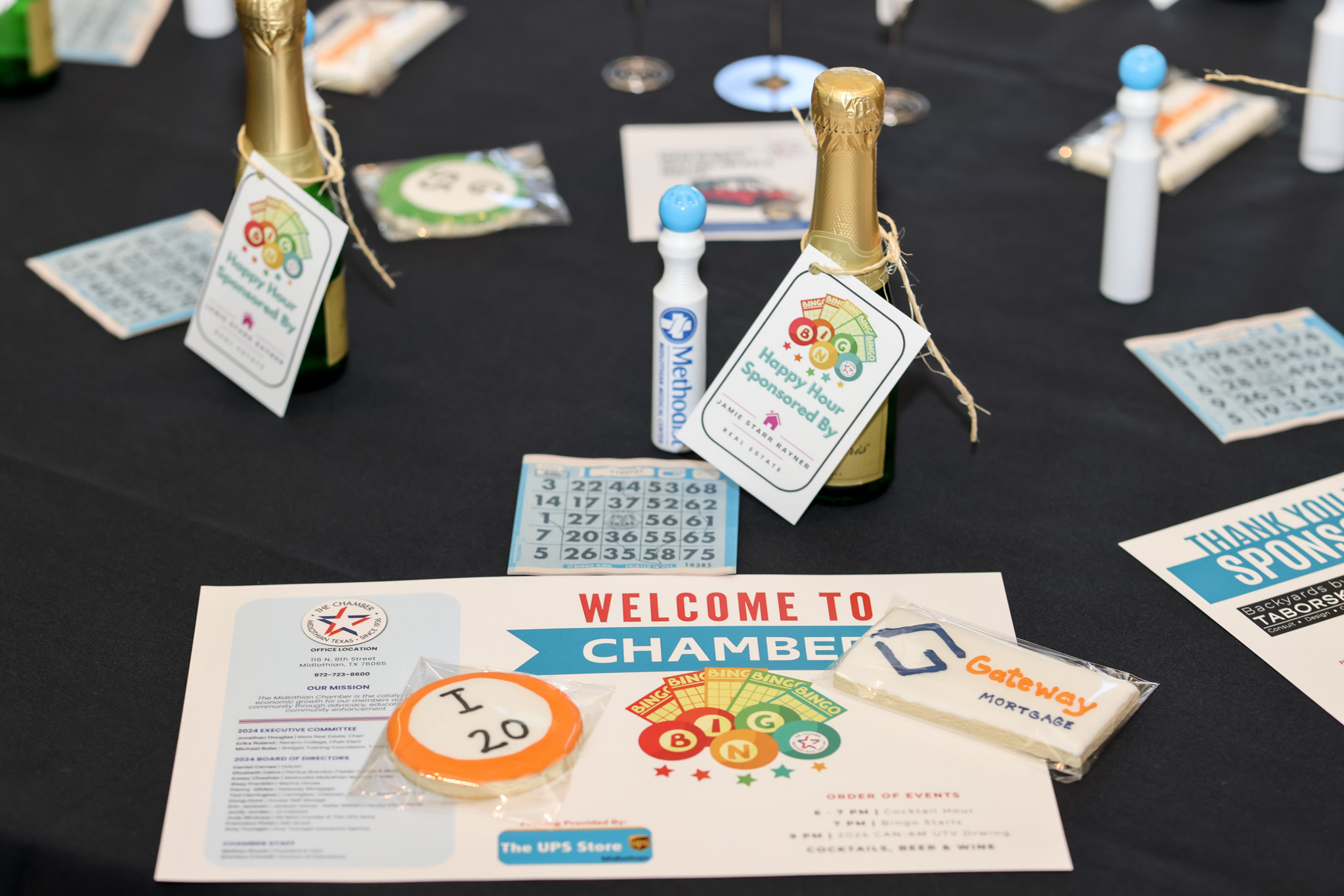 Table at Chamber Bingo Night with bingo cards and champagne bottles