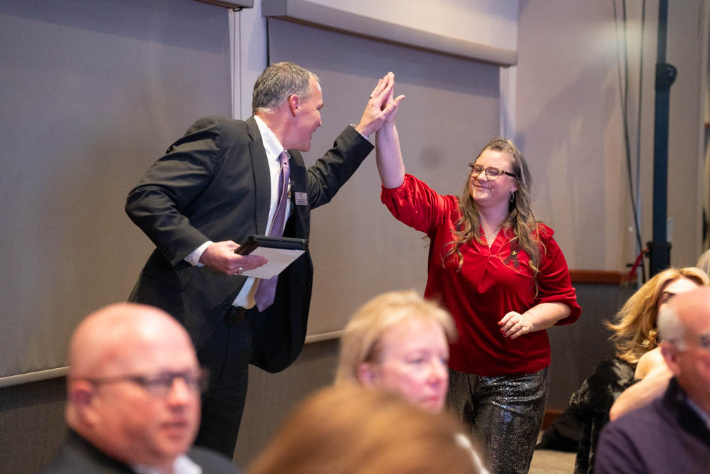 Two professionals high-fiving at Midlothian Chamber of Commerce event