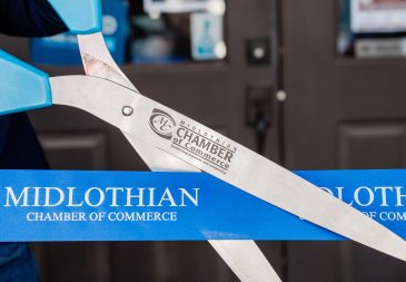 Staff member cutting ribbon in front of Midlothian Chamber of Commerce office