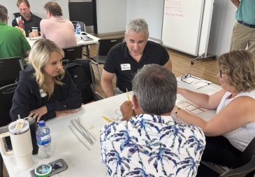 Group of professionals collaborating on a project in a classroom