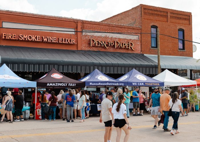 People walking through busy street of Chamber MidloFest vendors