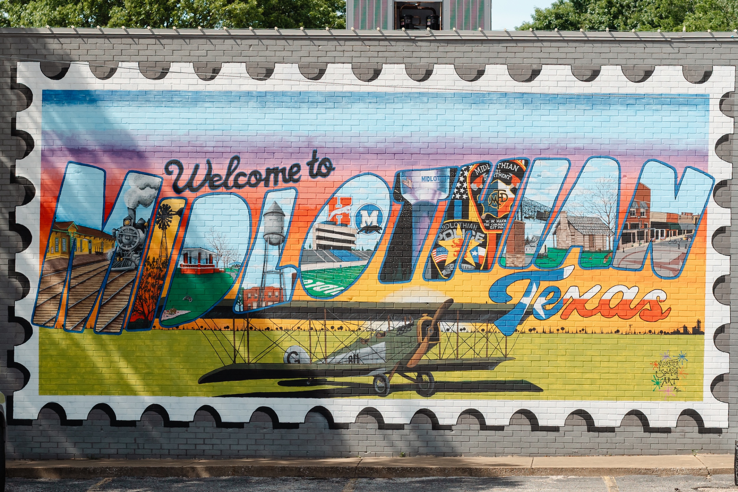 Large mural reading "Welcome to Midlothian, Texas" with colorful imagery of the city