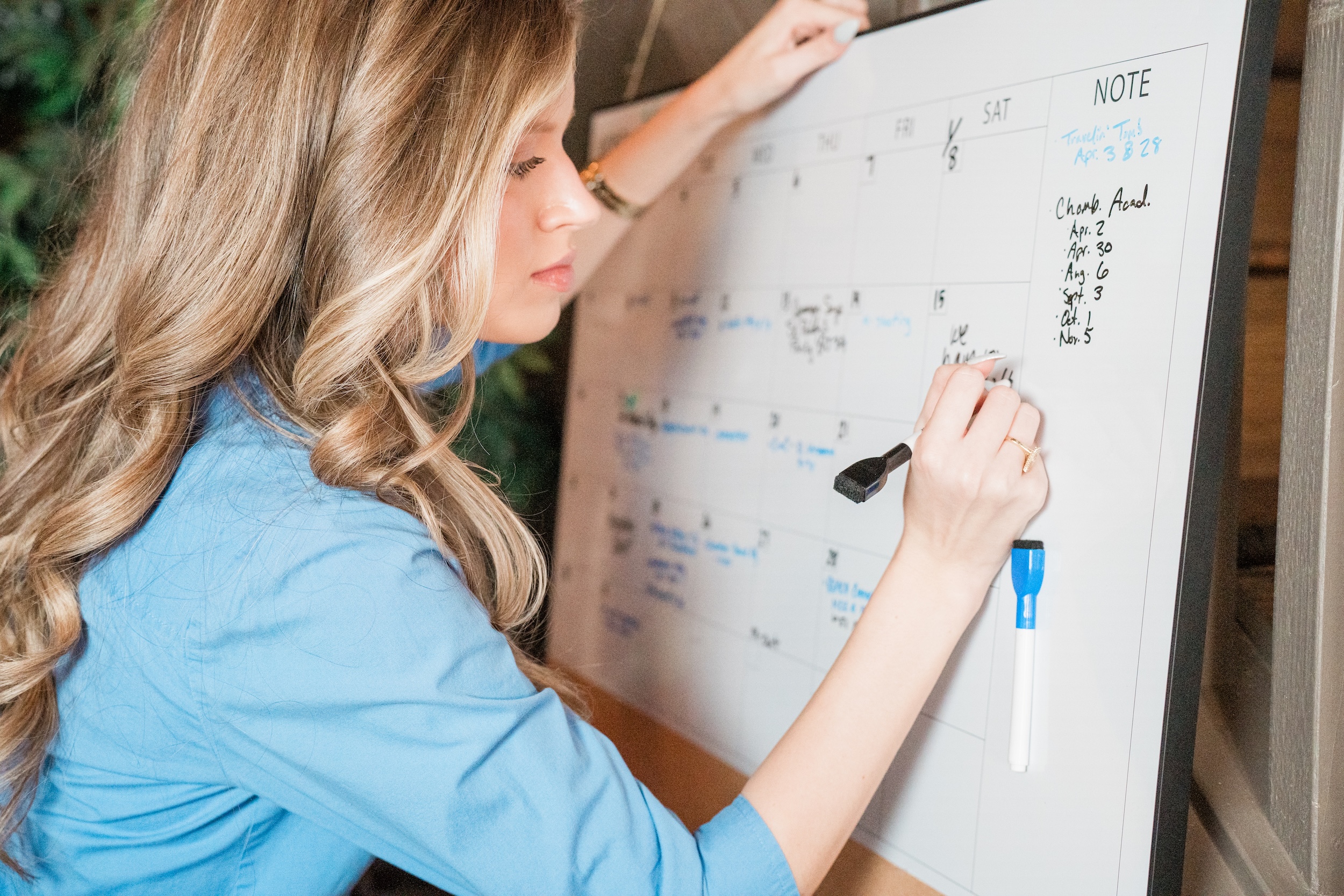Kenna Standridge writing on whiteboard calendar in Midlothian Chamber office
