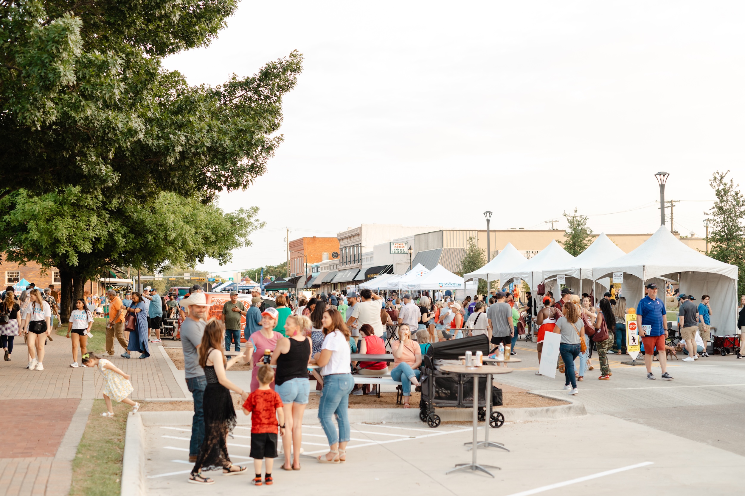 Busy street full of attendees and Chamber MidloFest vendors